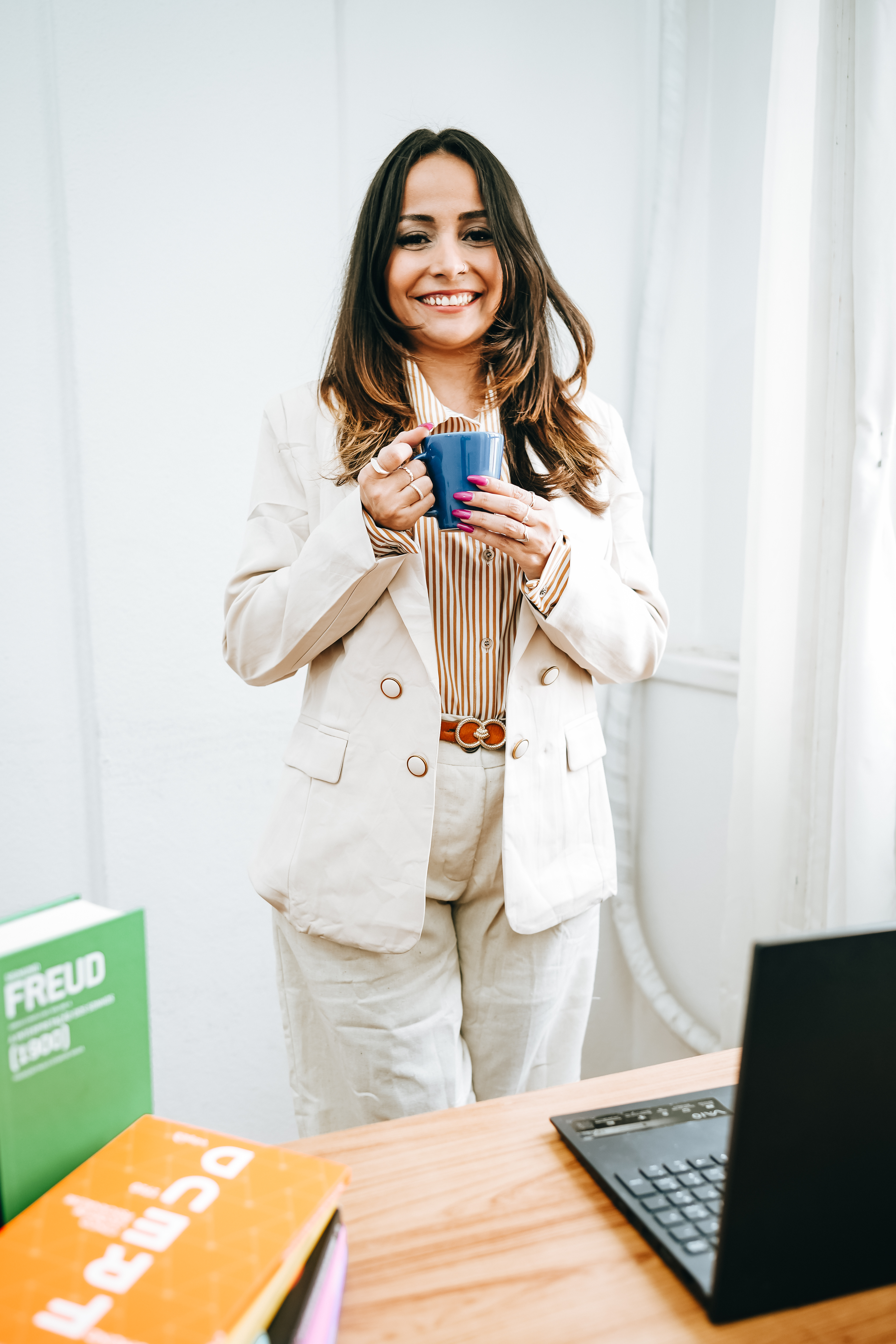 Jane Christiane, psicóloga psicanalista, sorrindo em seu consultório